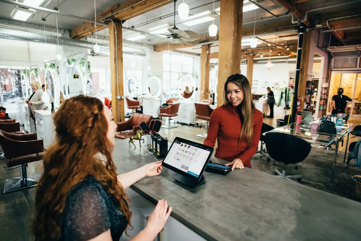 A customer pays a bill on a tablet at the counter.